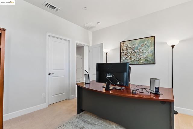 Office area featuring light colored carpet and baseboards