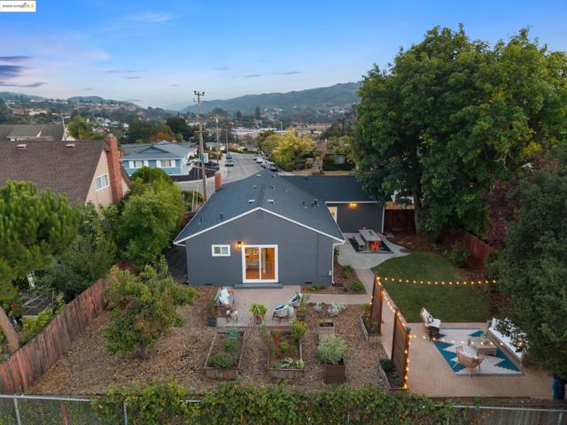 Rear view of property with a patio, a fenced backyard, a garden, a mountain view, and stucco siding