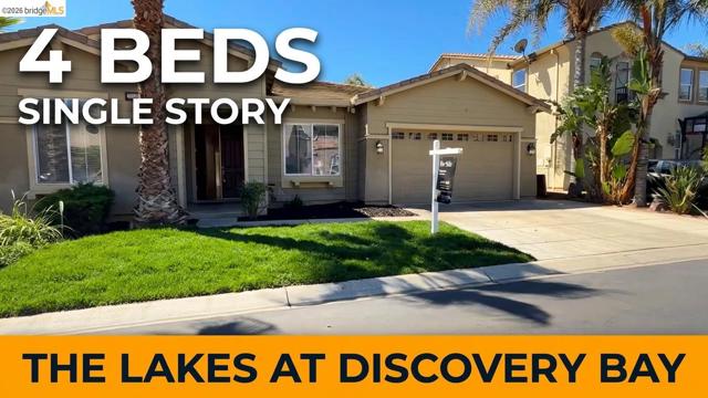Single-story residence featuring a two-car garage, concrete driveway, and a front lawn with established landscaping