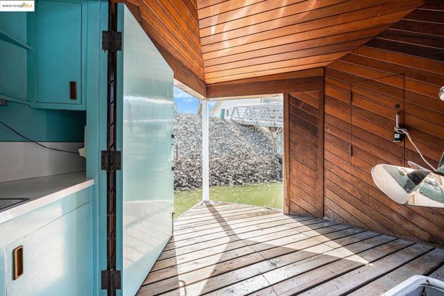 Doorway to outside with wood walls, wooden ceiling, and vaulted ceiling