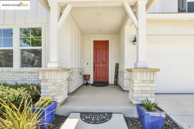 Doorway to property featuring board and batten siding and covered porch