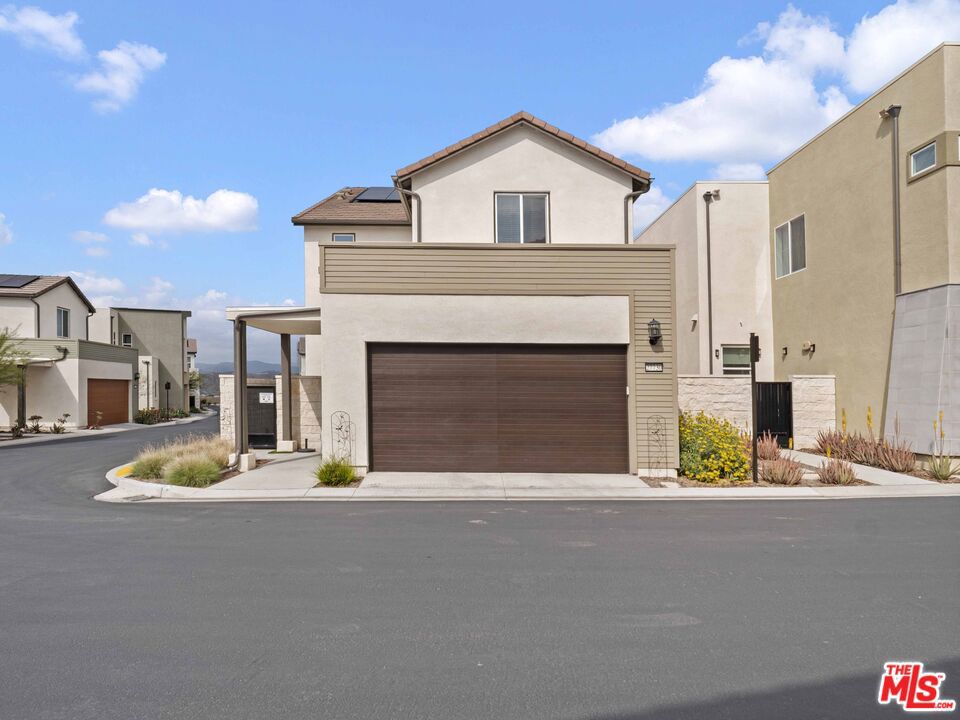 Welcome to this nearly new, beautifully upgraded 3-bedroom, 3.5 Bath view home in the highly desirable FivePoint community, offering over 2,400 square feet of open-concept living and owned solar! Step into the bright and spacious great room featuring luxury vinyl plank flooring, a generous dining area, and a seamless flow into the living room and chef's kitchen. The kitchen is a showstopper with a large center island, sleek quartz countertops, stainless steel appliances, and an oversized custom pantry with built-in shelving. Upstairs, the expansive primary suite features a private balcony with stunning views, spa-inspired en-suite bath with dual sinks, a soaking tub, glass-enclosed walk-in shower, and a massive walk-in closet. Desk space that is perfect for a homework station or home office. Laundry room with custom door, tons of storage and powder room for guests. There are two additional bedrooms on the second level, one with an en-suite bathroom and another full bathroom. Additional highlights include a whole-home water filtration system, custom blinds throughout, and a spacious covered patio perfect for outdoor living. Enjoy all the lifestyle perks of FivePoint, including resort-style pools with cabanas, BBQ areas, a community garden, playgrounds, scenic walking trails, mountain views, and a modern clubhouse ideal for gatherings. Conveniently located near Magic Mountain, shopping, dining, and with easy freeway access this home truly has it all!