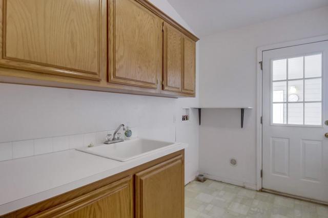 Inside laundry room with utility sink and extra fridge!