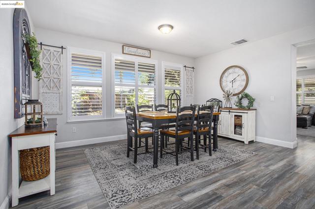 Dining space featuring laminate wood-style floors and 5 1/2 in. baseboards, with Plantation Shutters through-out.