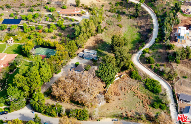 Seize the rare opportunity to own in one of Malibu's most coveted locations. Nestled in the picturesque Bonsall Canyon, this expansive four-acre property, owned by the same family for over 60 years, offers a seamless blend of convenience to the beach, schools, and shopping, coupled with unrivaled privacy and tranquility. The charming Ranch home, gracefully positioned on beautifully landscaped grounds, comprises five bedrooms and inviting living spaces. It includes an attached guest house, stables, a two-car garage, shed/workspaces, and an old riding ring. Majestic oaks and mature sycamores further enhance the natural allure of the surroundings. Whether you envision a haven for horse lovers, an artist's retreat, or a family sanctuary, this estate, with its breathtaking landscape and potential for expansion, presents a unique and unparalleled opportunity to craft your own Malibu masterpiece.