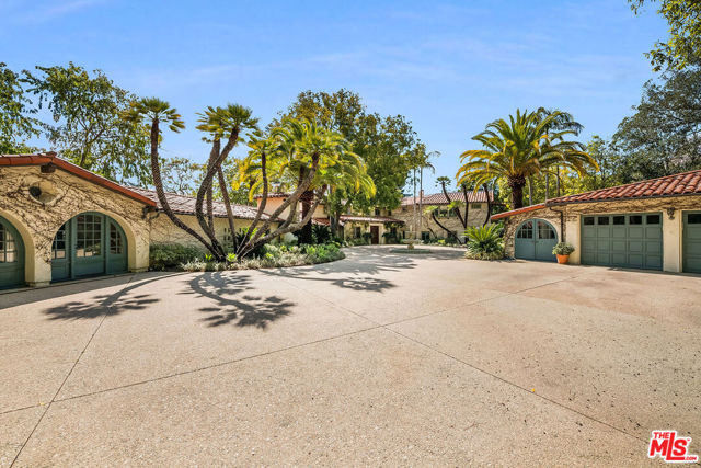 This beautiful Spanish villa hides behind double wrought-iron gates in complete privacy and security.  Located on a cul-de-sac in the most prime section of Bel Air, this property is one of the largest flat properties that directly adjoins the Bel Air Country Club Golf Course. A long private driveway leads to a huge circular motor court with center fountain and adjacent three-car garage. Situated on apx 2.5 acres, this property offers incredible golf course, ocean and city views, expansive lawns, gardens, private pathways, towering trees, and resort-like pool and spa. Originally built in 1953, this home was then expanded and renovated in the early 1980's. Currently spanning apx. 7,500 sq.ft., the main house offers a stately facade and elegant public rooms. Enter into the formal foyer leading to the gorgeous sprawling living room with hardwood floors, beamed ceilings, stone fireplace, and walls of doors opening to the back patio and overlooking the city, golf course, and ocean views beyond. Large formal dining room, library with fireplace, family room, and gourmet kitchen with adjoining breakfast room. There are 7 bedrooms in the main house, including 2 bedroom and 2 bathroom staff quarters and the generous master suite. The detached guesthouse features a living room, kitchen, bedroom and bathroom. Come experience the allure of this enchanting Bel Air property offering boundless opportunity in this prestigious setting.