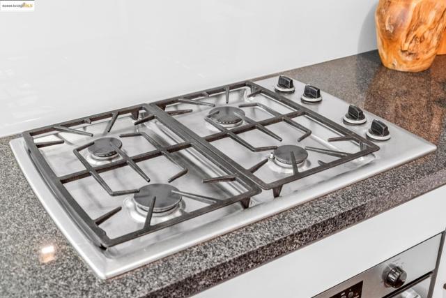 Kitchen view of gas cooktop and dark countertops