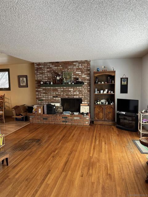 Hardwood floors and a brick fireplace, hearth and a nice mantel