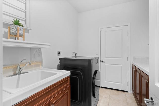 Laundry room with sink and storage. Access door to 3 car garage