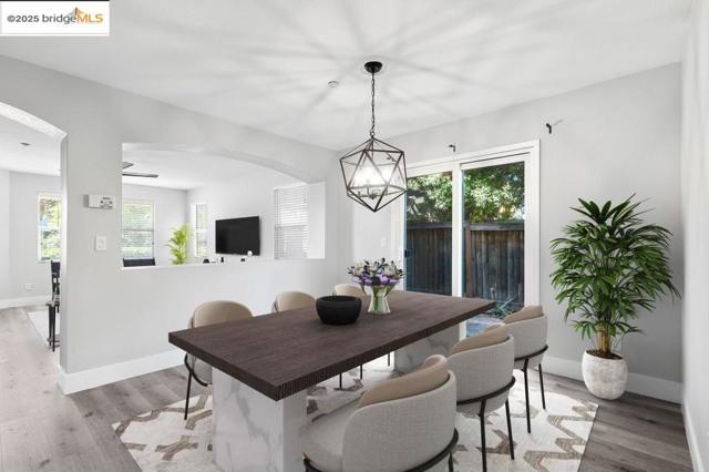 Dining space with plenty of natural light, light wood finished floors, and arched walkways