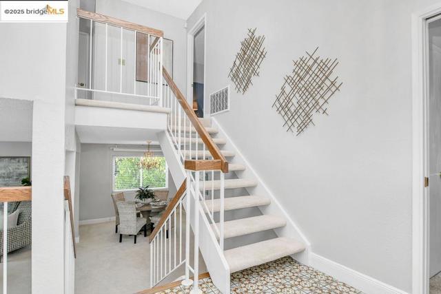 Stairway featuring baseboards and a high ceiling