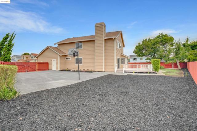 Back of property with a fenced backyard, a gate, a chimney, and a wooden deck