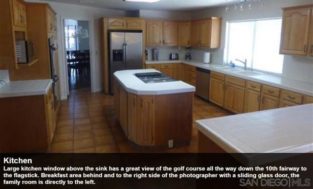 Large kitchen window above the sink has a great view of the golf course all the way down the 10th fairway to the flagstick. Breakfast area behind and to the right side of the photographer with a sliding glass door, the family room is directly to the left.