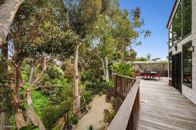 Escape from the living room French doors to the expansive deck with peaceful nature surroundings