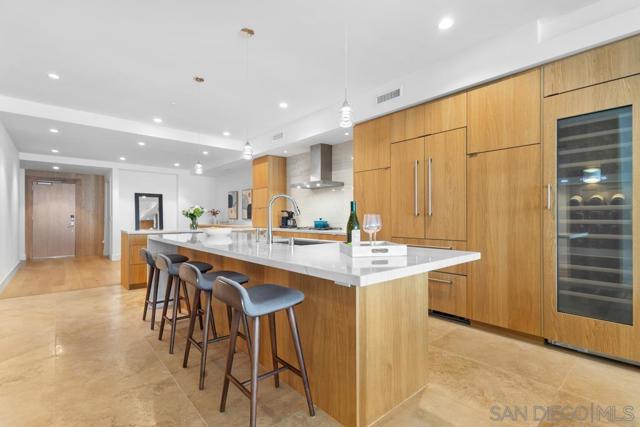 Luxurious chef's kitchen featuring built in Miele appliances, spacious island with Macaubus quartzite granite countertops, Shinnoki sustainable custom wood cabinetry and imported Turkish stone tile flooring.