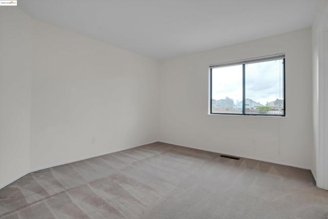 Unfurnished room featuring light carpet and baseboards