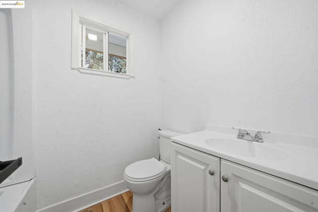 Bathroom featuring light wood finished floors, vanity, and a textured wall