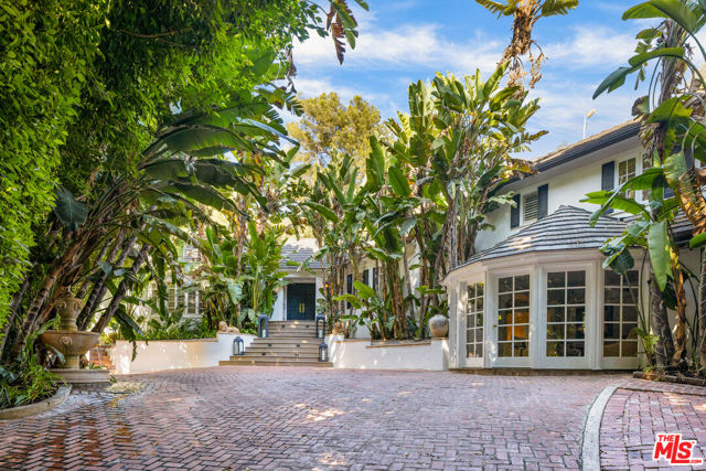 5630 Valley Oak Drive Los Angeles, California Walled and gated celebrity compound offering the ultimate in security and privacy. Located on a peaceful cul de sac, the only sounds to be heard are the bubbling waters of the estates 5 outdoor fountains. Enter through double doors into open floor plan living room that flows into family room, bathed in light from skylights in 20 foot ceilings, adjacent to larger formal dining room that seats 14! Open kitchen, fully equipped for family or chef, black granite countertops, dual ovens and 2 dishwashers. French doors open to a breakfast patio with a built in gas BBQ. Large primary suite with vaulted ceilings and stone fireplace with French doors leading to a dedicated , private deck, His and hers major closets, completely finished for luxury. Two additional bedrooms in main house have extra-large closets and en-suite baths. Lower level features professional grade screening room, featuring ultra hi definition and sound, with seating for 11 plus bar seating as well. Additionally, enjoy the entertainment/game room with French doors opening to rear of pool area. Plus one more bedroom that can be a playroom or office. Totally separate, complete, guest house set poolside, amidst patios, complete with kitchenette and full bath. Lounge in heated pool while you watch the big game on your Sunbrite outdoor TV or relax and enjoy your outdoor fireplace. The entire estate is beautifully and lushly landscaped with large green palms and ferns for privacy or zen chilling.