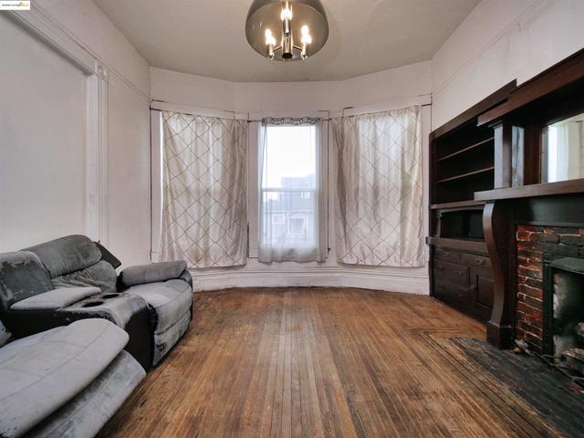 Living area with hardwood / wood-style flooring, a brick fireplace, and a chandelier
