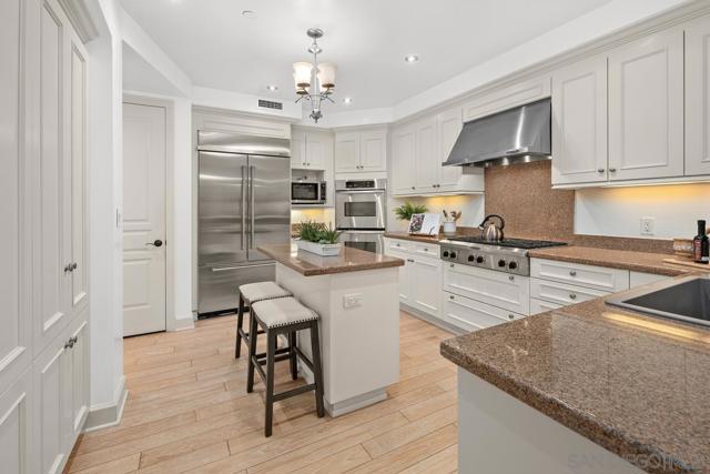 The kitchen features a center island, custom painted cabinets, stainless steel appliances, and ample cabinetry to inspire your culinary endeavors.