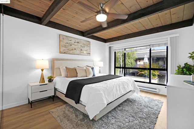Bedroom featuring a wooden ceiling with exposed beams, wood finished floors, ceiling fan, and a baseboard radiator