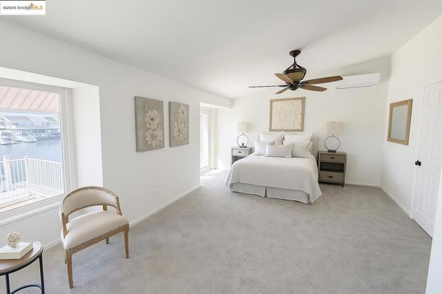 Bedroom with lofted ceiling, carpet floors, a ceiling fan, a wall mounted air conditioner, and a water view