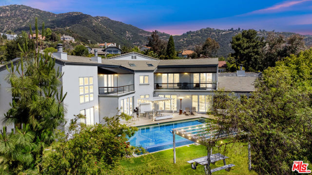 Currently the lowest price per square foot in Malibu! With 6,195 square feet of living space - including a detached guest house - this is one of the largest homes you can get for this price on the east end of town. This private corner lot features a 4-bedroom main house, a one-bedroom two-story guest house with a loft, a 3-car garage, and an additional 2-car garage, as well as a pool, spa, grassy yard, circular motor court, basketball hoop, and gated entry - this home has it all. Experience the Malibu lifestyle in this conveniently located neighborhood, just 7 minutes from the beach and 10 minutes from the heart of Calabasas. The architectural style and floor plan of the main house allow for sunlit rooms and open, flowing entertaining areas. The main level features a sunken living room, a large office, a dining area, and one bedroom. Two additional bedrooms, and the primary bedroom with an expansive bathroom, all have balconies to enjoy the fresh air and view the backyard, pool, and peak-a-boo ocean views. The backyard offers a patio off the kitchen, a huge pool, and grassy areas for play. Malibu awaits...
