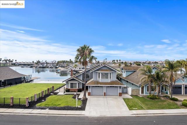 View of front of property with an attached garage, a water view, and concrete driveway