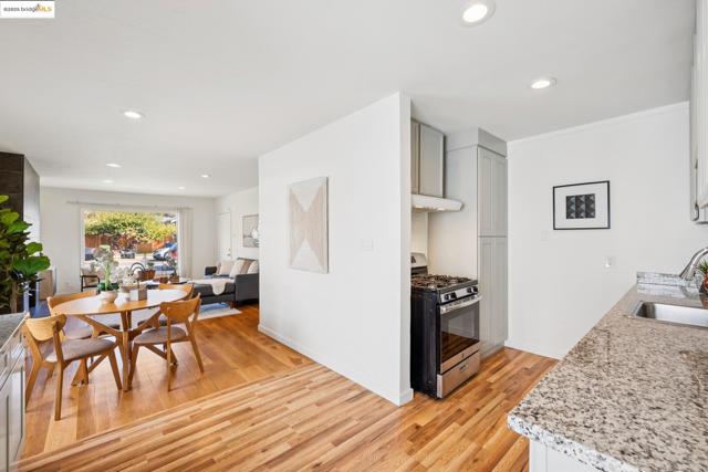 Kitchen featuring stainless steel range with gas stovetop, recessed lighting, light wood finished floors, light stone countertops, and open floor plan