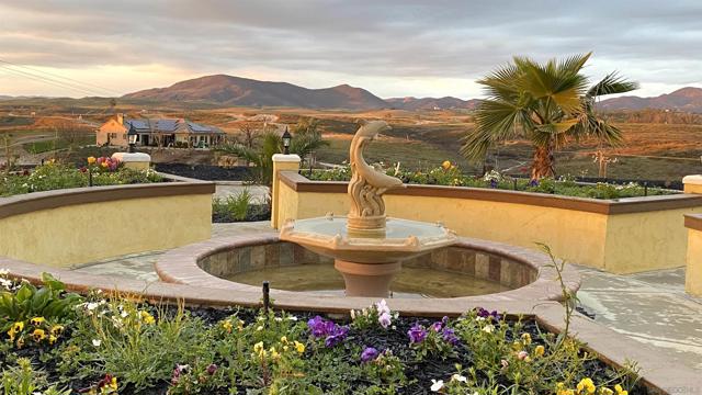 The fountain with flower beds in the front yard.