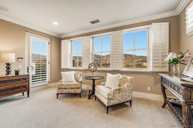 Spacious primary suite with stunning views, abundant natural light, and a cozy sitting area. Plantation shutters and elegant finishes create a serene retreat.