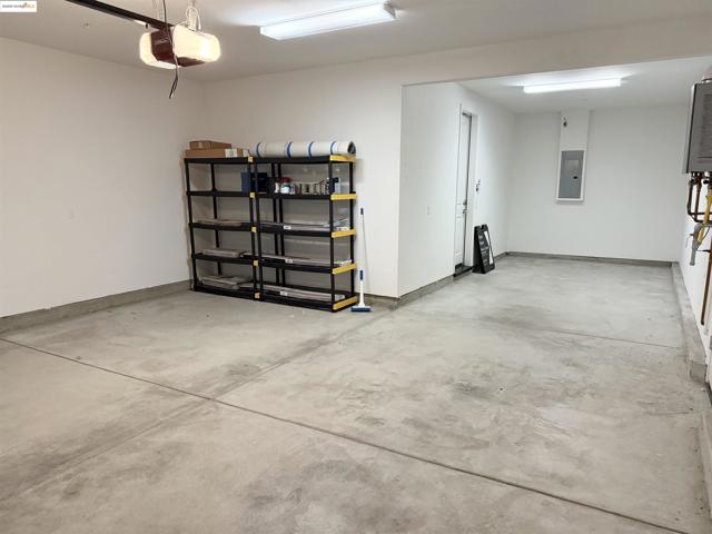 Garage featuring electric panel and a garage door opener