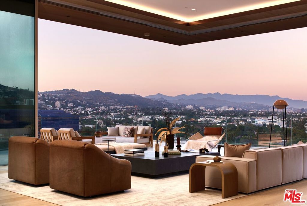 Home to commanding views of the iconic Los Angeles skyline and San Gabriel mountains, Penthouse East at 8899 Beverly presides over the city with inimitable grace and timeless style. Classic beauty and understated drama define Penthouse East, with its soaring 14' ceilings, full-height wood paneling, expansive views, and a dramatic wraparound terrace in timeless stone from which to take it all in.  Discretion and convenience are paramount throughout the design, offering a semi-private elevator, as well as a separate entrance and service corridor for staff members, assistants, or catering staff. With historic mid-century appeal and exceptional handcrafted design, the Penthouse at 8899 Beverly offers  floor-to-ceiling Swiss Vitrocsa glazing with operable panels to blur the line between indoors and out. A nearly 2,000 SF wraparound terrace in Italian Travertine stone makes an ideal place from which to enjoy sweeping city views. Crafted by Olson Kundig Architects, 8899 Beverly stands as an iconic collection of 40 Tower Residences, each representing a unique expression of luxury living.At 8899 Beverly, a full-service building, you can expect attentive staff that ensures a five-star living experience.  Amenities include 24-hour concierge and valet services, a fitness center, and a quarter-acre oasis with a resort-style pool, spa, fireplaces, and a custom outdoor kitchen. Within a short walk, you'll discover premier dining and shopping destinations. An exciting addition to the building is Stella's Restaurant, a collaboration between renowned restaurateur Janet Zuccarini and Executive Chef Rob Gentile, enriching the exceptional lifestyle offered at 8899 Beverly.