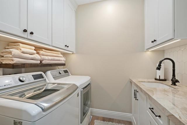 The upstairs laundry room has a beautiful glass door for privacy, plenty of built-in storage including a trash pull out.