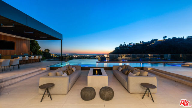 Broker who brings a successful buyer who closes escrow before April 1, 2023 to receive a $1,000,000 bonus.  Situated on an ultra-private, tree-lined hillside in Bel Air, this spectacular new estate is an entertainer's paradise that captures magnificent, far-reaching city and ocean views. Envisioned by Bowery Design Group with interior design by Faye Resnick, the estate boasts 1.3 acres, 7 bedrooms, 14 bathrooms, 2 pools on different levels, amazing water features throughout such as a large indoor atrium and water wall and endless amenities for indoor-outdoor entertaining. Enjoy dual chef's kitchens, a pantry, and living/dining areas open through glass walls to lounging terraces, outdoor kitchen, custom bar, infinity-edged pool and spa. On the lower level, find a lounge, bar, 12-seat theater, wine room, and an indoor-outdoor gym with a steam room and sauna that leads to a 2nd, 73' pool that extends over the hillside. 7 bedroom suites include staff quarters and a stunning primary suite with 2 closets. Features include an office, oak floors, and 2 garages with parking for 5. Capturing sunrise to sunset views, enjoy the utmost privacy, minutes from the city's best shopping and dining.