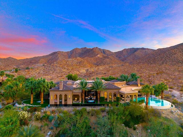 Step into the serene embrace of Casbah Cove, a Moroccan-inspired masterpiece perched in the prestigious BIGHORN community. Blending timeless elegance with modern luxury, this private sanctuary offers wellness and relaxation in the heart of Palm Desert.Intricate woodwork and geometric patterns reflect Morocco's rich heritage, while a retractable glass ceiling crowns the central courtyard, inviting sunlight by day and moonlight by night. Relax under the stars or unwind in the indoor spa as the glass roof opens above, creating an ethereal connection to nature.The home features 4 ensuite bedrooms, including a private guest house, each with outdoor access, and a versatile bonus room for a fifth bedroom, gym, or theater. Designed for both entertaining and tranquility, it boasts a dramatic 75-foot lap pool, a Moroccan-inspired circular pool, and two spas--one offering breathtaking city light views and another near a fireplace, steam shower, and wine cellar.The primary suite is a haven of indulgence, offering an indoor-outdoor bathroom with a champagne chiller by the tub. Whether hosting yoga sessions, private chef dinners, or enjoying quiet solitude, every detail elevates your living experience.Framed by sweeping views of the Santa Rosa Mountains and city lights, Casbah Cove balances social accessibility with private tranquility. Moments from the exclusive BIGHORN Canyons Steakhouse, it's more than a home; it's a retreat and a testament to refined living.