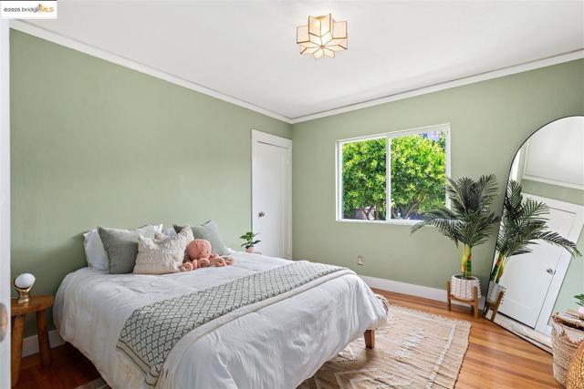 Bedroom featuring ornamental molding and wood finished floors