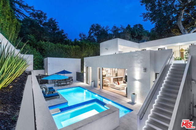 Modern Sophistication at its finest! This 2018 built home has all the bells and whistles. Perched atop a  private, peaceful tree lined street this spacious beauty neighbors the notable Trousdale Estates and is just minutes away from the world famous Beverly Hills Hotel and Rodeo Drive.  Inside an exclusively gated driveway, a soaring 25' grand entry embellished with dual skylights and the unique "EYE OPENING" poppy light fixture above. Open floor plan with pool view is perfect for entertaining or just chilling in the many enclaves. Chef's kitchen features Wolf appliances, Sub Zero Fridge & Freezer, abundant cabinetry and pantry.  5 Bedroom, 5 bath (2 Master Suites) Modern amenities added include Halo water purification/softener system, KNX controls, Savant Smart Home System, Specialty Lighting, TV/ Sound system through out including inside Master shower. 360' LED Landscape lighting. Enchanting, grandiose Sycamore tree surrounded by lavish Timber Tech deck. Outdoor Bar, Fire Pit, Shower, Built-In Grill, spacious Spa seats 10. Built in wall safes, wet bar, refrigerator, freezer, dual fireplace in Master Suite/Retreat. Garage features added workshop area. Awesome entertaining decks above with an impressive private gym. VIP Guest & Delivery side entry with secured video Intercom access. A must see for the most discriminating buyer!