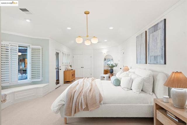 Carpeted bedroom featuring ornamental molding, arched walkways, and recessed lighting