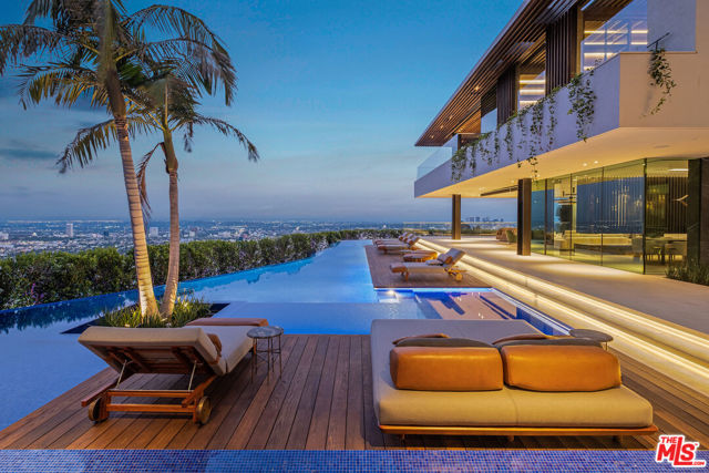 From world-renowned architectural design firm, Saota, this 20,000 sq. ft. estate is set on a promontory with unparalleled 300 degree city skyline views boasting unmatched design and exquisite bespoke finishes throughout. Automated glass sliding doors create a seamless confluence from the interior living spaces to plentiful outside seating and dining areas, including a 175-foot linear pool culminating in a waterfall cascading into an atrium garden. A 15-foot outdoor television rises from the ground with horizontal and vertical rotation, visible from every room in the house. Enormous entertainer's rooftop deck, state-of-the-art theater, curated wine cellar, glass elevator, unrivaled security and audio/visual integration, and a spa retreat replete with wet and dry sauna, cold and hot water plunge pools, and massage therapy. Private driveway leads to a multi-car garage. Unquestionably the most impressive property ever built above the Sunset Strip.