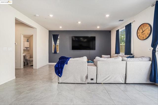 Living room with light tile patterned flooring and recessed lighting