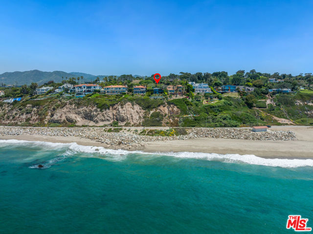 Perched on Birdview bluff above scenic Westward Beach, this light-filled contemporary residence has the amenities of a vacation resort and the deeply rewarding comforts of home. Commanding sweeping ocean and island views, the approximately 0.57-acre property is richly landscaped and terraced, with balconies, decks, and patios. From the gated entry, the long drive passes a tennis court with stadium lighting and a swimming pool and spa in a very private garden setting with a wide flagstone pool deck for lounging. The drive ends in a motor court with ample guest parking, and the home opens to reveal breathtaking ocean views from a stunning great room. With cathedral ceilings, a corner fireplace, a window seat, beautiful wood floors, and handsome built-ins, the great room has expansive ocean-view windows and glass doors that slide away to provide seamless access to the wraparound deck for al fresco dining and entertaining. A lovely dining area shares the views, and the professional chef's kitchen is just beyond, featuring an island with bar seating, marble countertops, a beverage cooler, quality appliances, and a wide garden-view window above the sink. Off the kitchen is a mud room with a door to the side garden where there is a water feature and an outdoor shower. Also on the entry-level are two bedrooms, a full bath, and a powder room. Steps near the front door lead down to the ocean-view primary suite, which occupies the entire lower level. This private haven has a sitting area with a fireplace,  closet, generous built-ins, and a wall of glass opening onto a partially shaded patio and gorgeous ocean views. The primary bath, which also has ocean views, has a door to the backyard as well as access to an additional storage/closet/laundry room. On the ocean side of the house, the backyard provides numerous options for entertaining and relaxation, with a large flagstone patio, a lawn, a firepit area with seating surrounded by a mature succulent garden, and a deck with sitting areas that overlook the beach, the waves, and views to the horizon. The home has central air conditioning, a two-car garage, outdoor irrigation, and a full complement of smart-home features, including automated window shades, Sonos sound, and security. This is an estate of exceptional quality and comfort. Available for lease $65,000 per month.